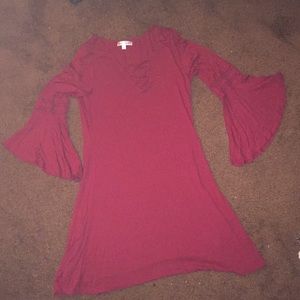 A red dress that is half sleeved flared sleeves .